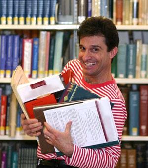 Man in striped shirt holding books